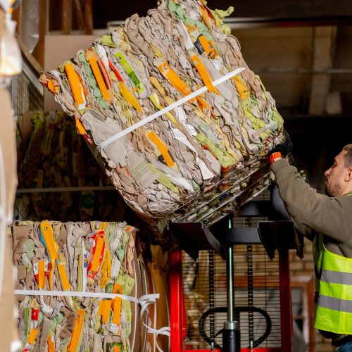 A worker at a waste treatment station takes out a large box of things at waste treatment center